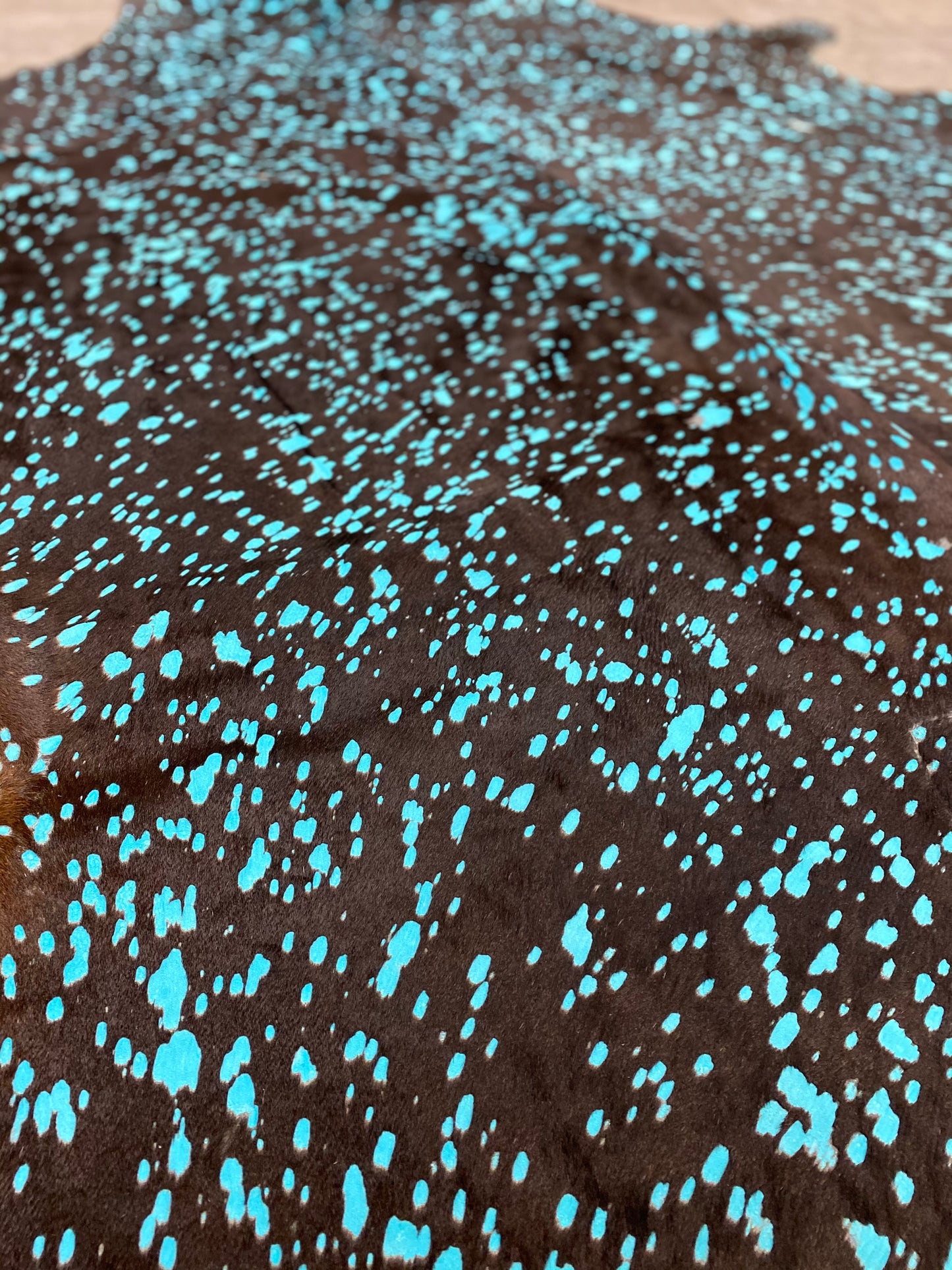Dyed turquoise on black cowhide